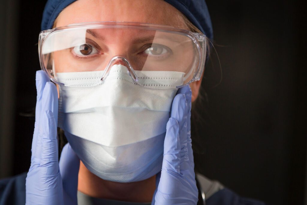 A nurse in gloves and a face mask.